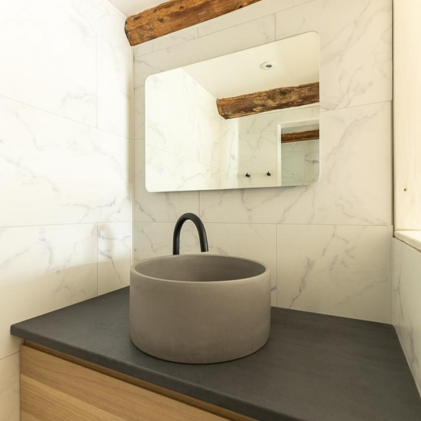 Salle de bain du Domaine de la Chouette avec vasque en béton, marbre blanc et bois.