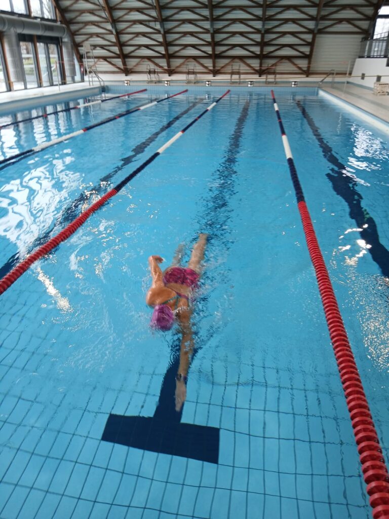 “Nageuse en entraînement dans la piscine d’Ambert, dans un bassin intérieur lumineux.